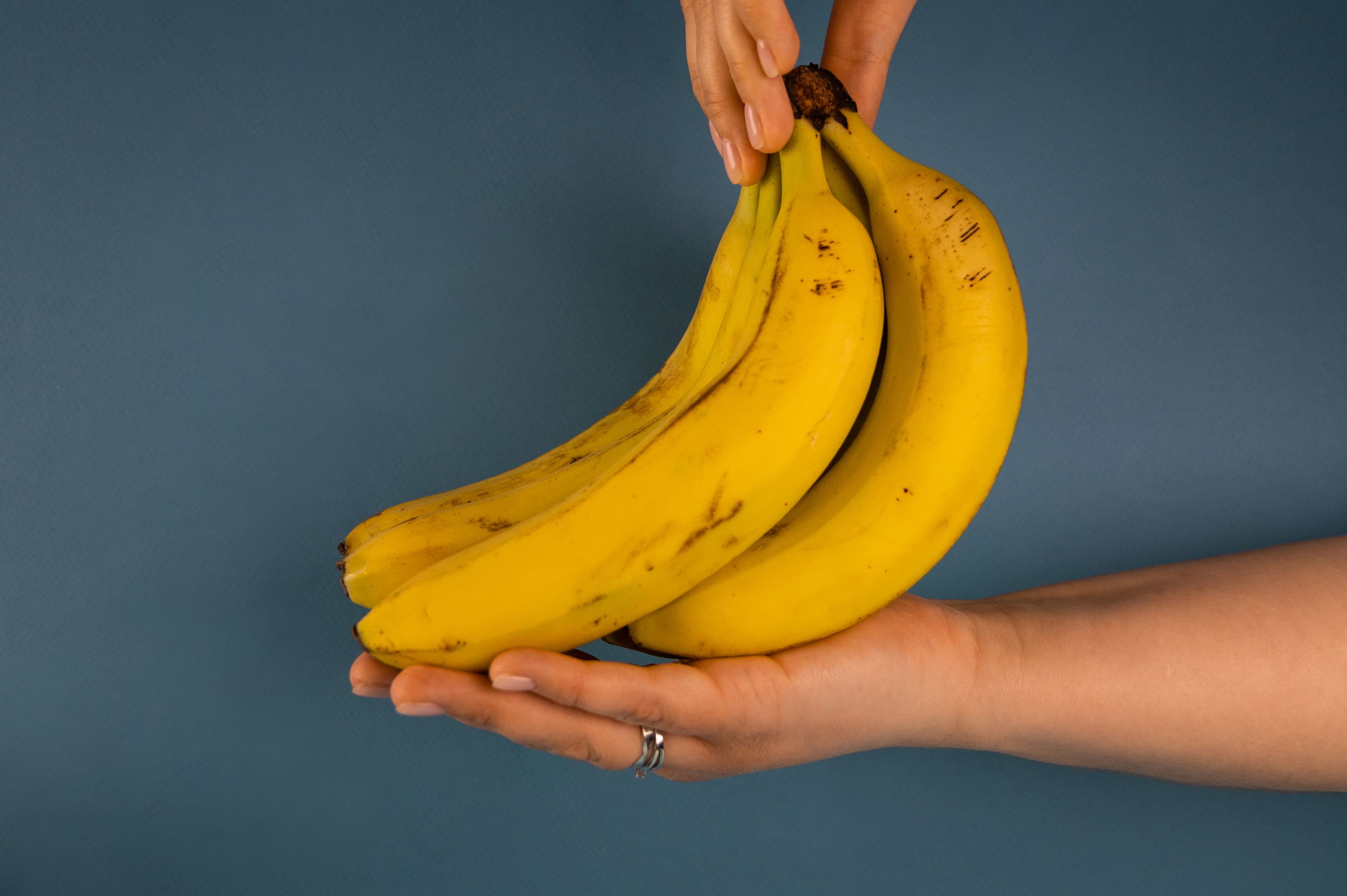 A bunch of ripe plantains held in two hands